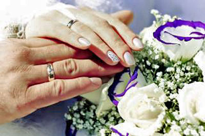 An image of hands with wedding rings.
