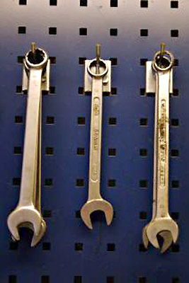 An image of wrenches hanging on a peg board.