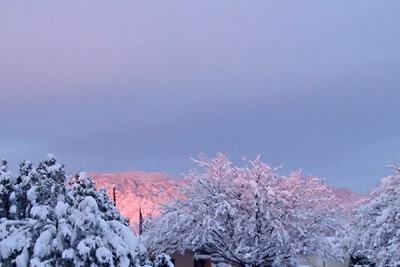 A photo of the Sandias covered with snow at sunset.