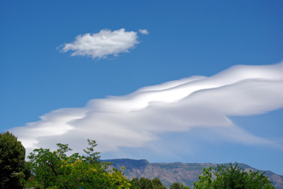 A photo of mountain wave clouds over Sandia Crest.