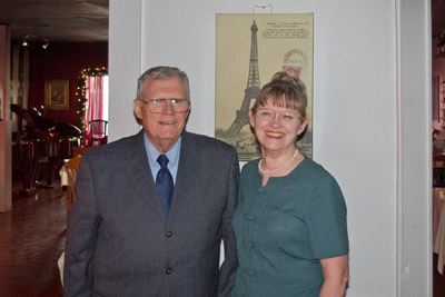 A photo of Morris and Mary with their favorite French restaurant in the background.