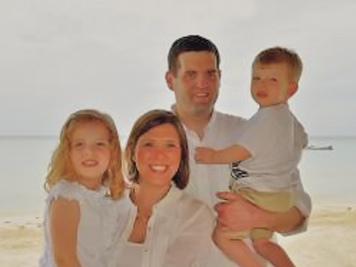 A photographic image of a family of four at the beach.