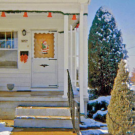 A photographic image of a house with red Christmas bells on it.
