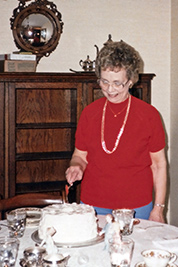 A photographic image of Mom Webb cutting a cake on her 66th birthday.