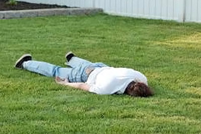 A photographic image of a man sleeping on a lawn.