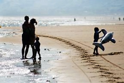 A photographic image of a family at a beach.