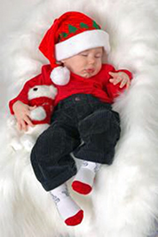 A photographic image of a baby in Christmas finery.