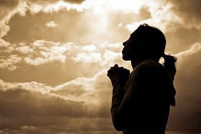 A photographic image of a woman in prayer.