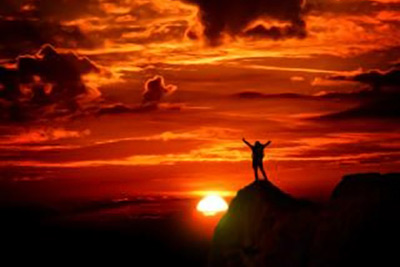 A photographic image of a man on top of a mountain.