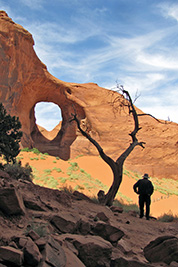 A photographic image of Morris Webb, Jr. viewing a hole in a rock.