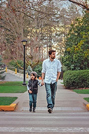 A photographic image of a father walking with his son.