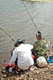 A photographic image of two men fishing.