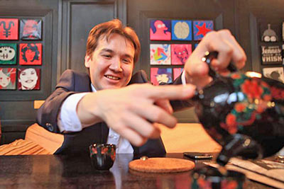 A photographic image of a businessman pouring hot tea.