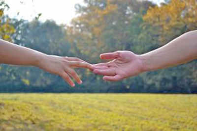 A photographic image of two hands touching.