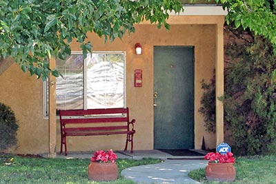 A photographic image of a small house with a green door.