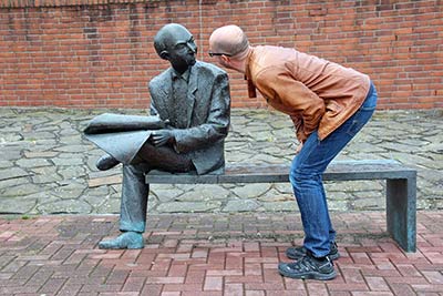 A photographic image of a man talking to a sculpture..