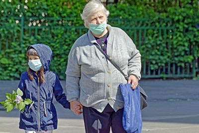A photographic image of a child and a grandmother wearing a mask.
