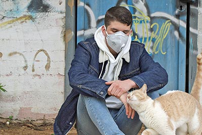 A photographic image of a young man and his cat.