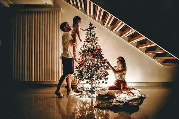 A photographic image of a young family and their Christmas tree.