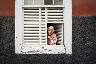 A photographic image of a lady in a window.
