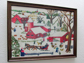 A photographic image of a crewel needle painting of a farm scene.