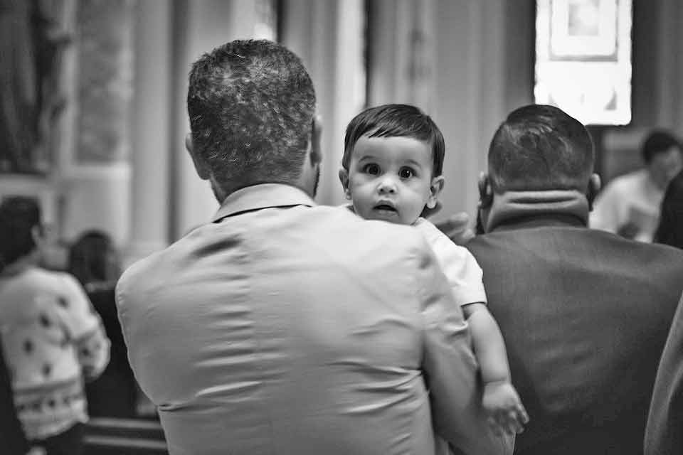 A photographic image of a father and baby in church.