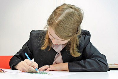 A photographic image of a schoolgirl writing.