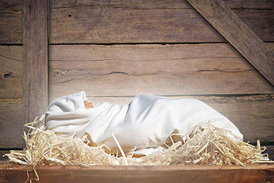 A photographic image of a baby in a manger.