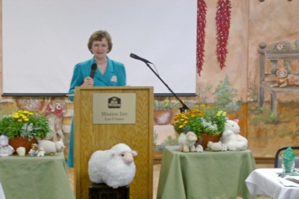 Mary at the speaker's podium in Las Cruces, Nw Mexico, surrounded by her flock of stuffed sheep.